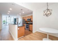 Open kitchen features wood cabinets, stainless steel appliances, and a large island at 3040 Peachtree Nw Rd # 815, Atlanta, GA 30305
