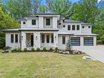 Striking two-story modern home featuring a stone facade, two-car garage, and professionally landscaped front yard at 340 Colewood Way, Atlanta, GA 30328