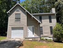 Two-story home with neutral siding, attached garage, and manicured front yard at 3948 Valley Brook Rd, Snellville, GA 30039