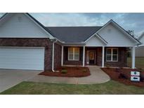 Charming brick home with a well-manicured lawn and an attached garage at 210 Park Place Trl, Social Circle, GA 30025