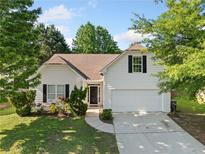 Charming one-story home featuring a manicured lawn, attached garage, and classic architectural details at 5478 Somer Mill Rd, Douglasville, GA 30134