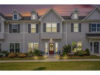 Charming townhome featuring a red front door, gray siding, and well-manicured landscaping at 1702 Prospect Way, Conyers, GA 30094