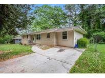 Charming single-story home features a brick exterior and mature trees at 3367 Misty Valley Rd, Decatur, GA 30032