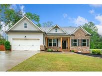 Charming single-story home with brick and siding exterior, lush lawn, and two-car garage at 8230 Dawson View Way, Cumming, GA 30028