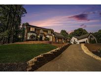 Beautiful brick home featuring a long driveway and well-manicured lawn at 180 Spring Ridge Trace, Roswell, GA 30076