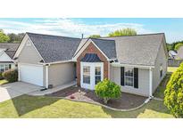 Charming single-story home featuring a well-manicured lawn and attached two-car garage at 2602 Midler Ct, Buford, GA 30519