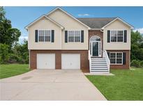 Charming two-story home with brick and vinyl siding, an arched front door, and a two-car garage at 5447 Lauren Cv, Ellenwood, GA 30294