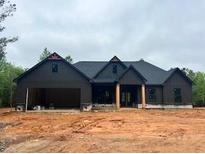 A charming, single-story home featuring a dark gray exterior, an attached garage, and a well-manicured lawn at 816 Proctor Rd, Rockmart, GA 30153