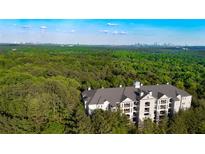 Stunning aerial view of condo building surrounded by trees with distant city skyline backdrop at 4100 Paces Se Walk # 4306, Atlanta, GA 30339