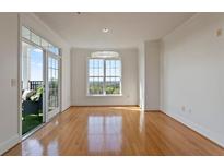 Bright living room with hardwood floors, large window, and access to a balcony at 4100 Paces Se Walk # 4306, Atlanta, GA 30339