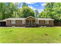 Charming single-story home with a well-manicured front yard and inviting front porch at 5855 Willis Ln, Cumming, GA 30040
