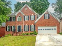 Charming two-story brick home with a well-manicured lawn and a two-car garage in a suburban neighborhood at 1485 Oglethorpe Run Ln, Suwanee, GA 30024