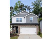 Charming two-story home with a stone-accented facade, a well-manicured lawn, and an attached two-car garage at 283 Wells Cir, Canton, GA 30114