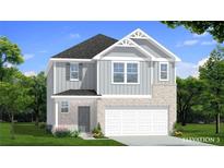 Charming two-story home featuring stone accents, gray siding, manicured lawn and a two-car garage at 286 Abbotts Crossing Cir, Conyers, GA 30094