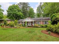 Charming brick home features a large front yard with lush landscaping at 4527 Sims Ct, Tucker, GA 30084