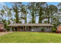Charming gray home featuring a carport, wood accents, and a spacious front yard at 3653 Mecklinburg Pl, Decatur, GA 30032