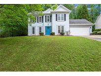 Charming two-story home with a well-maintained lawn and a bright blue front door at 6939 Waters Edge Dr, Stone Mountain, GA 30087