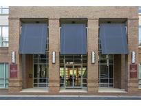 Welcoming entrance to 711 Cosmopolitan building featuring brick facade, modern awning and glass door entryway at 711 Cosmopolitan Ne Dr # 123, Atlanta, GA 30324
