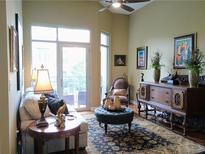Bright living room with a ceiling fan and large sliding glass doors leading to a private balcony at 711 Cosmopolitan Ne Dr # 123, Atlanta, GA 30324