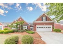 Charming brick home with manicured landscaping, a two-car garage, and inviting curb appeal at 1022 Pecan Grove Pl, Lawrenceville, GA 30046