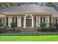 Charming brick home featuring a well-manicured front yard and inviting double door entrance at 1585 Lazy River Ln, Sandy Springs, GA 30350
