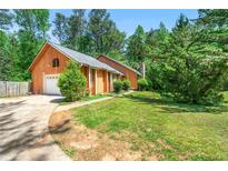 Charming home with beautiful wood siding, a well-manicured lawn, and attached garage at 3955 Old Fairburn Sw Rd, Atlanta, GA 30331