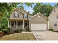 Charming two-story home with a welcoming front porch, a two-car garage, and a well-manicured lawn at 4560 Weathervane Dr, Alpharetta, GA 30022