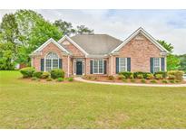 Charming brick home with well-manicured lawn and lush landscaping at 1719 Kings Cross Ct, Hoschton, GA 30548
