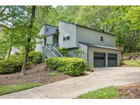 Two story home with gray siding, a two car garage, and a stairway leading to the front door at 4274 Revere Cir, Marietta, GA 30062