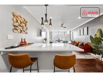 Stylish living room features a breakfast bar, hardwood floors, and an orange velvet sofa at 215 Piedmont Ne Ave # 1509, Atlanta, GA 30308