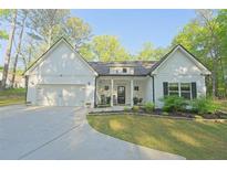 Charming single-story home with a manicured lawn, covered porch, and attached garage, nestled in a wooded location at 453 Mulberry Rock Rd Rd, Temple, GA 30179