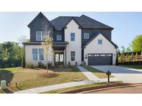 Charming two-story home featuring a mix of painted brick and vertical siding, an attached two-car garage, and well-manicured lawn at 750 Garden Reserve Ln, Alpharetta, GA 30005