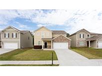 Inviting two-story home featuring a well-manicured lawn and attached two-car garage at 7747 Rudder Cir, Fairburn, GA 30213