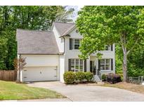 Charming two-story home with a white brick exterior, well-manicured landscaping, and attached two-car garage at 6000 Hampton Bluff Way, Roswell, GA 30075
