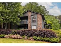 Inviting two-story condo with a brick facade, wooden balcony, and mature landscaping at 223 Tuxworth Cir, Decatur, GA 30033