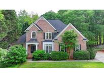 Charming two-story brick home with a manicured lawn and mature landscaping at 2973 Misty Rock Cv, Dacula, GA 30019
