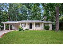 Charming single-story home features a manicured front yard, covered carport, and a classic painted brick facade at 2732 Elkhorn Dr, Decatur, GA 30034