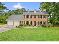 Charming two-story brick home with a well-manicured lawn and a two-car garage at 2801 Holly Oaks Dr, Marietta, GA 30062