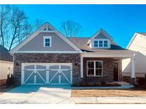 Charming brick home featuring a two-car garage and a welcoming covered porch, perfect for suburban living at 7220 Winderlea Ln, Cumming, GA 30040