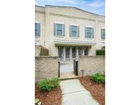 Charming brick townhome with gray shutters, private gated entrance, and manicured landscaping at 130 Forrest Aly, Roswell, GA 30075
