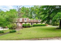 Charming brick home with manicured lawn and mature trees, providing shade and curb appeal at 620 Shannon Green Sw Cir, Mableton, GA 30126