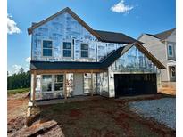 Exterior view of a new two-story home with an attached two-car garage and covered front porch, ready for finishing touches at 72 Warrior Ct, Braselton, GA 30548