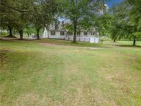 Charming home with a sprawling front yard and mature trees, offering a serene and private setting at 3241 Briscoe Rd, Loganville, GA 30052