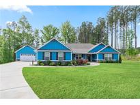 Charming blue home with a well-manicured lawn, complemented by a two-car garage and beautiful landscaping at 505 Alta Ct, Villa Rica, GA 30180