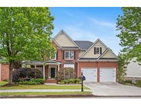 Charming two-story home featuring a well-manicured lawn, two-car garage, and a classic brick facade at 1692 Holcomb Lake Rd, Marietta, GA 30062