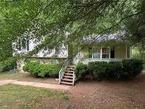 Charming home featuring a covered porch with lush landscaping surrounding the property at 2756 Del Ridge Dr, Douglasville, GA 30135
