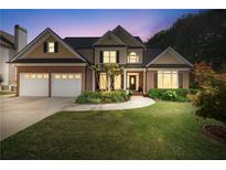 Two-story home featuring a well-manicured lawn, a two-car garage, and a charming front porch at 2978 Legislative Ln, Buford, GA 30519