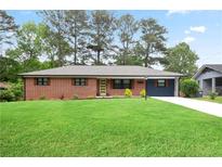 Charming brick home with a well-manicured lawn and a vibrant, yellow front door provides great curb appeal at 2738 Westchester Dr, Atlanta, GA 30344