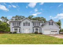 Two story light blue house with shutters and a lawn on a sunny day at 4129 Flakes Mill Manor Ln, Ellenwood, GA 30294