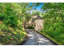 Secluded home featuring private drive surrounded by lush landscaping and mature trees at 5105 Jett Forest Trl, Atlanta, GA 30327